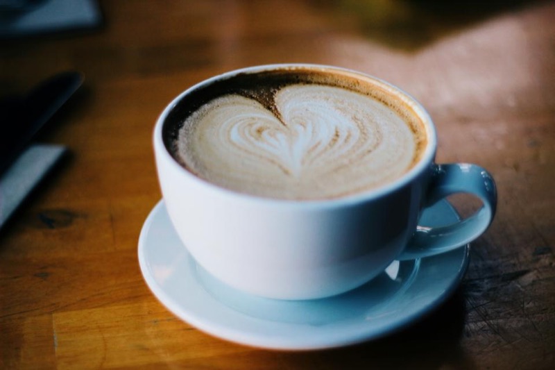 Cappuccino with heart latte art on a wooden table
