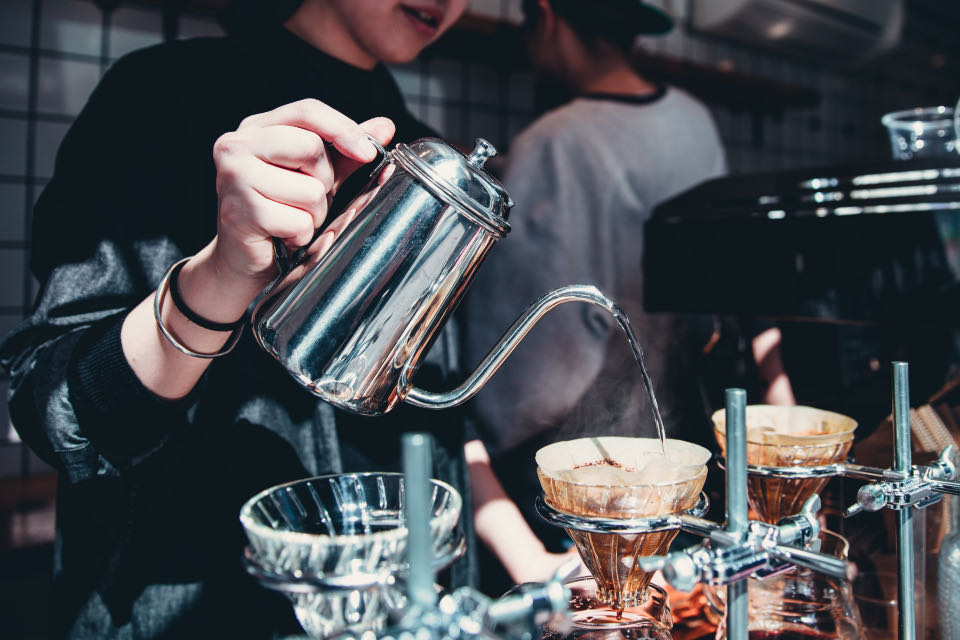 Barista pouring hot water over a pour-over coffee